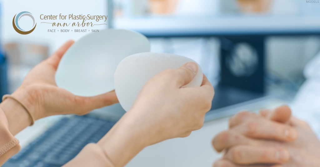 Hands holding breast implants during a consultation about breast implant safety and BIA-ALCL (model)