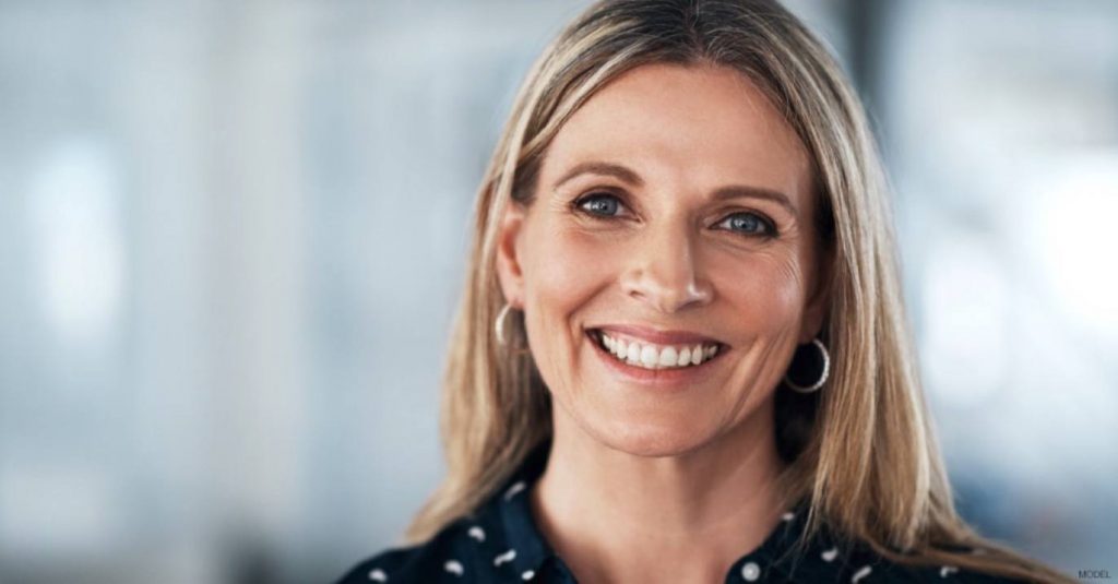 Woman smiling after eyelid surgery